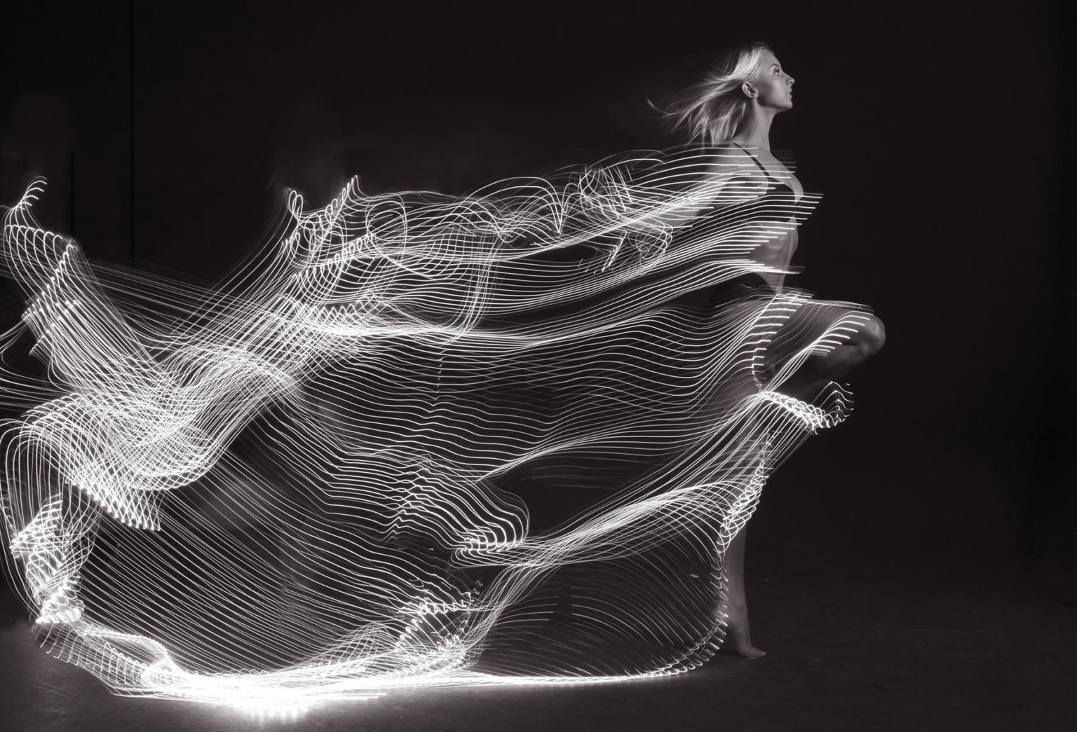 Woman Trailing Lights Showing How A Long Shutter Speed Leads To Flowy Images